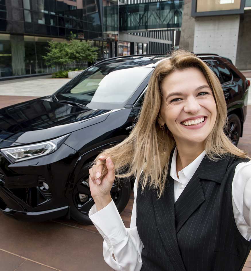 Усміхнена дівчина перед авто